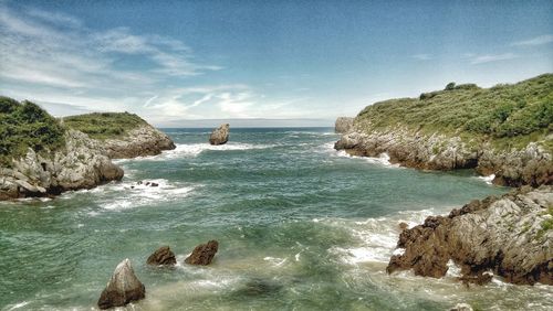 Scenic view of rocks in sea against sky