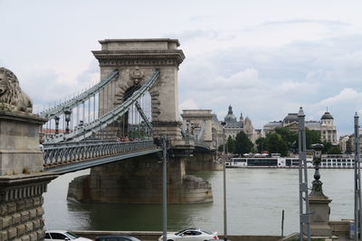 Chain bridge over danube river against sky in city
