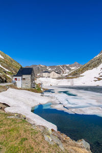 Scenic view of snowcapped mountains against clear blue sky