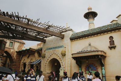 People in front of building against sky