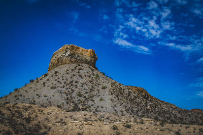 Low angle view of rock formations against blue sky