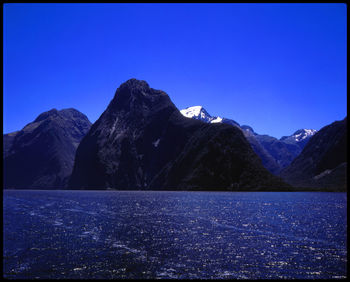 Scenic view of snowcapped mountains against clear blue sky