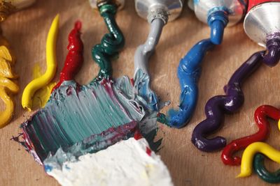 High angle view of colorful paints on table at workshop