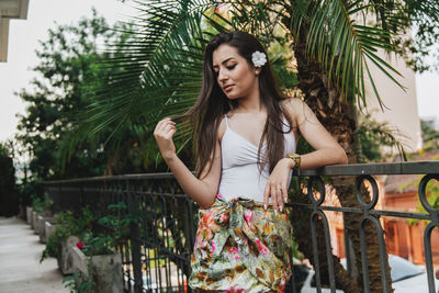 Beautiful young woman against tree