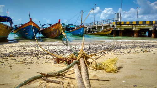 Boats moored on beach against sky