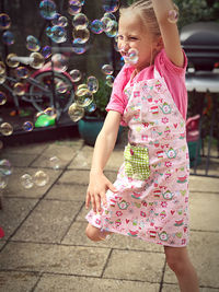 Full length of happy girl with bubbles