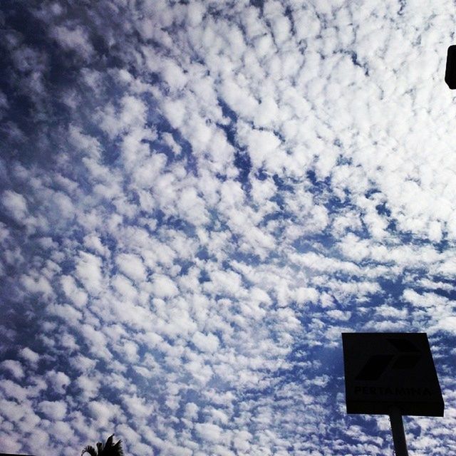 sky, cloud - sky, low angle view, communication, white color, nature, outdoors, sign, day, cloud, tranquility, guidance, weather, road sign, cloudy, no people, white, street light, scenics, tranquil scene