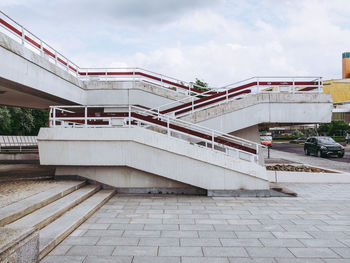 Bridge over street amidst buildings against sky