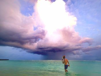 Full length of man standing on beach against sky