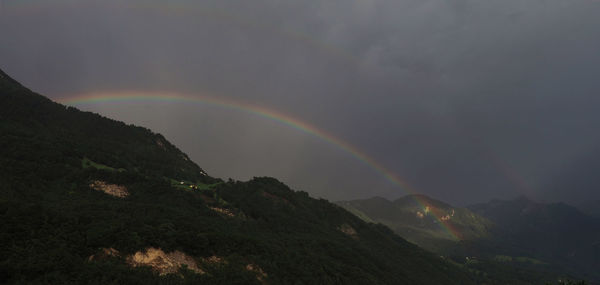 Scenic view of rainbow over mountains against sky