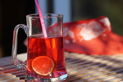 Close-up of drink with straw and lime slice on wooden table