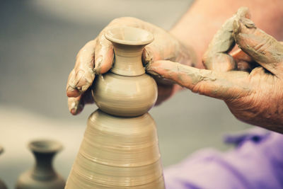 Cropped hand working on pottery wheel