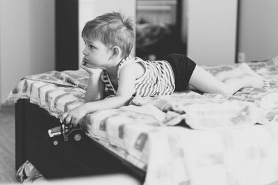 Boy sitting on bed at home