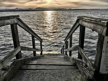 Pier over sea against sky during sunset