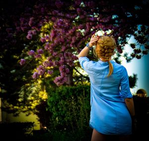 Rear view of woman standing against trees