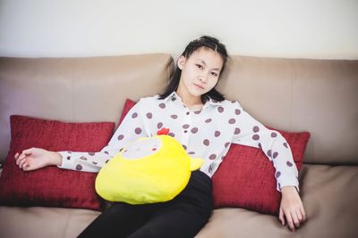 Portrait of smiling woman sitting on sofa at home