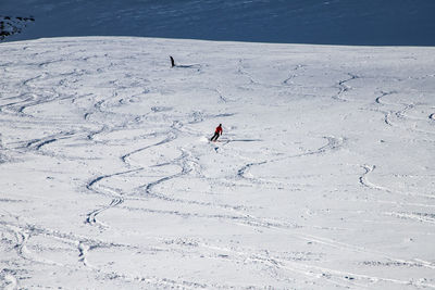 High angle view of people skiing on snowcapped land