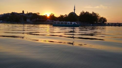 View of lake in city during sunset