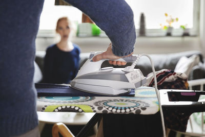 Cropped image of man ironing clothes at home