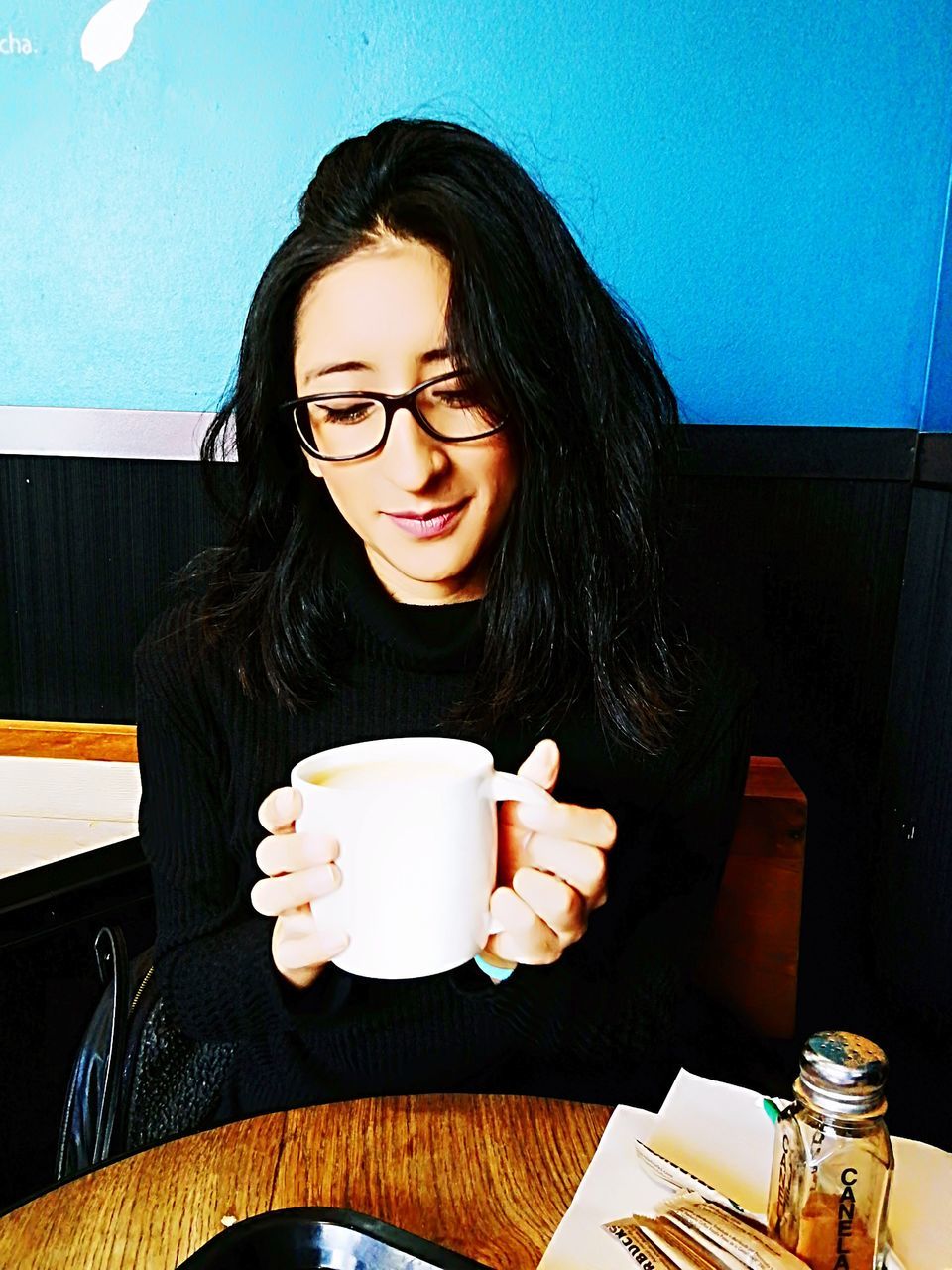YOUNG WOMAN SITTING WITH COFFEE