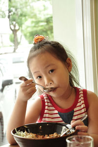 Portrait of boy eating food on table