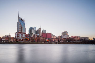 River by buildings against clear sky in city