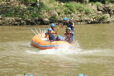 People rowing boat in river