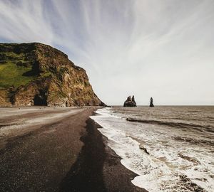 View of beach against cloudy sky