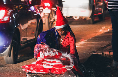 Woman selling santa hats on street in city