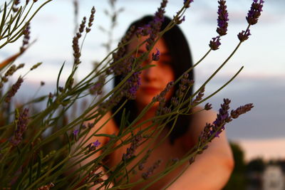 Close-up of hand on plant against sky
