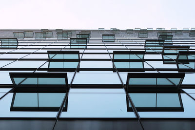 Low angle view of glass building against clear sky