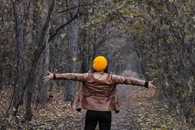 Rear view of person standing in forest