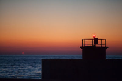 Silhouette of lighthouse at sunset