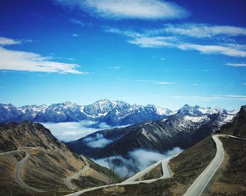 Scenic view of rocky mountains against blue sky during winter