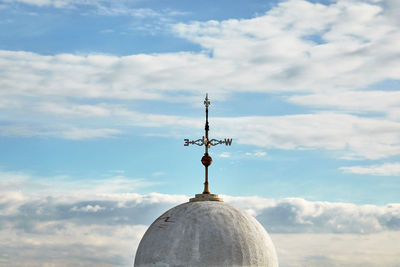 High section of cross against building