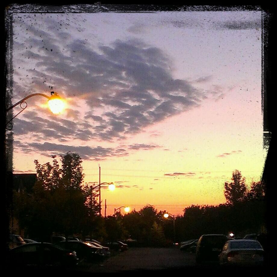 sunset, transportation, car, land vehicle, mode of transport, orange color, sky, silhouette, sun, street light, tree, cloud - sky, road, street, beauty in nature, parking, traffic, nature, dramatic sky, scenics