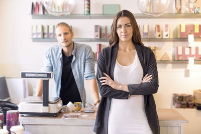 Portrait of female worker with colleague standing in candy store