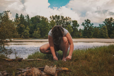 Man looking at lake against sky