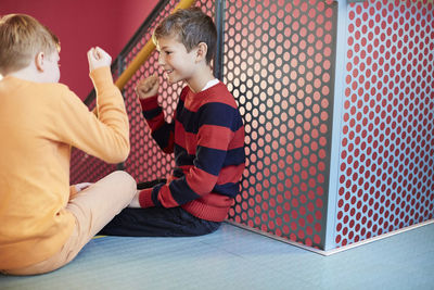 Middle school boys playing rock-paper-scissors on staircase