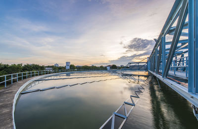 Bridge over river against sky in city