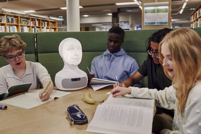 Friends sitting together in library
