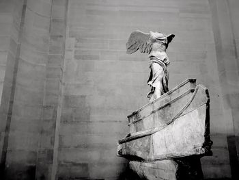 Man with umbrella against built structure