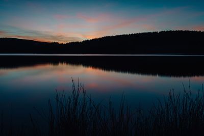 Scenic view of lake against sky at sunset