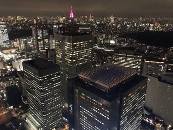 Aerial view of illuminated buildings in city at night