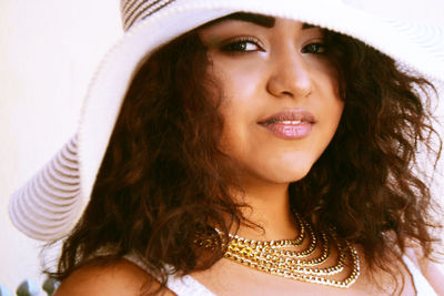 Close-up portrait of smiling young woman wearing hat