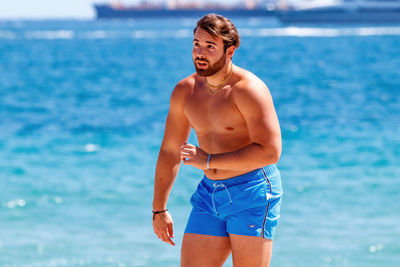Young man standing on beach