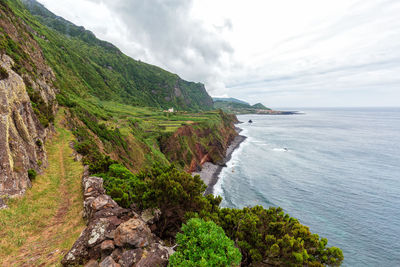 Scenic view of sea and mountains against sky