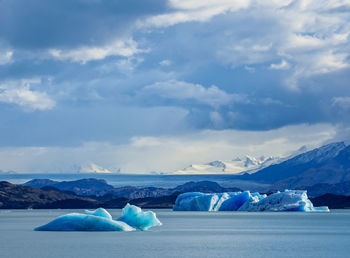 Ice floating on water in winter against sky