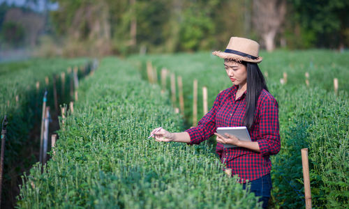 Young woman using mobile phone on field