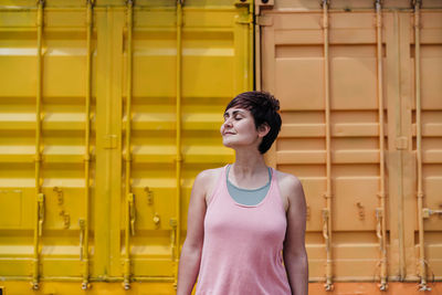 Woman standing against yellow wall